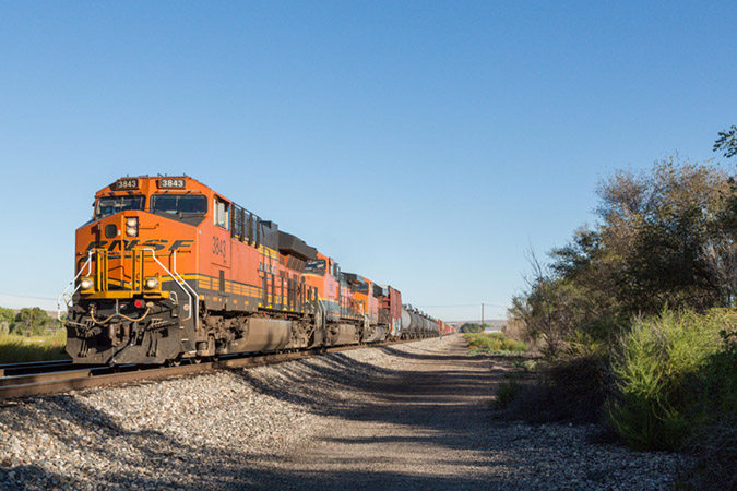 BNSF 3843, also a Tier 4 GE ET44C4, leads a mixed freight train toward a grade crossing. BNSF 3843, also a Tier 4 GE ET44C4, leads a mixed freight train toward a grade crossing.